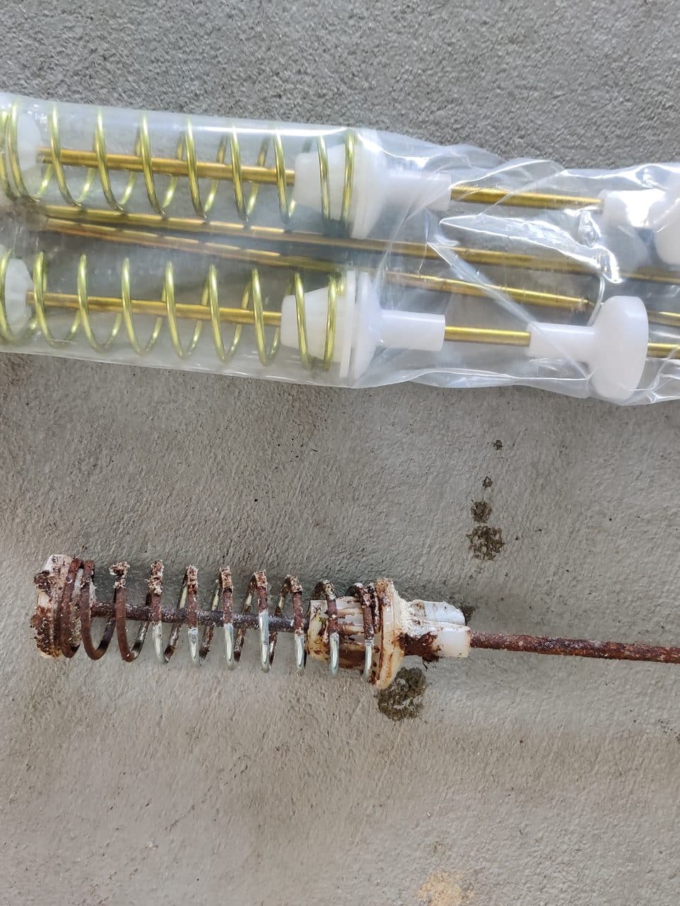 Old rusty suspension rod next to the new set: Samsung washer, model WA45T3200AW (washer repair in Palmetto Bay, FL, July 2026)