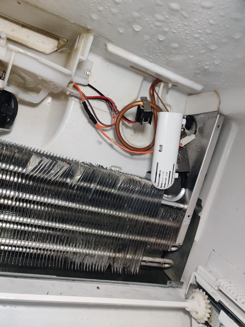 Refrigerator evaporator coils with the defrost heater exposed